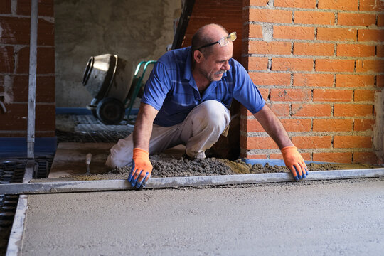 Construction worker smoothing concrete above the radiant floor system.