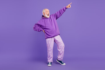 Full length body size view of cool cheerful man pointing clubbing having fun isolated over bright violet purple color background © deagreez