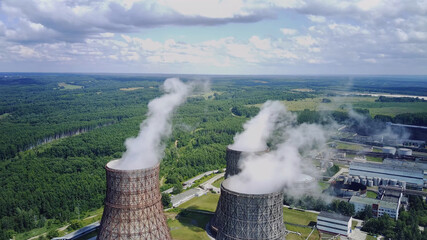 Steam from large pipes at a nuclear power plant, clouds, blue sky