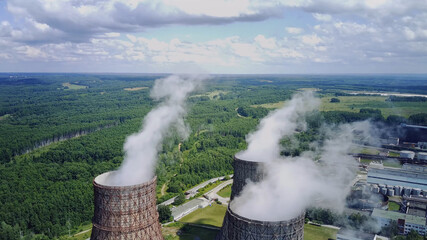 Steam from large pipes at a nuclear power plant, clouds, blue sky