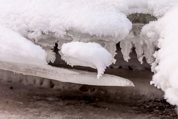 Icicles and frost on a snow-covered frozen river