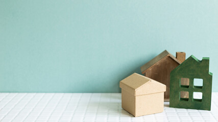 House model on white ceramic mosaic tile table. mint background. Real estate concept