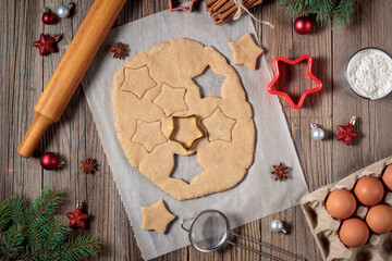 Baking homemade Christmas gingerbread cookies. top view of holiday background with dough spices and fir tree.