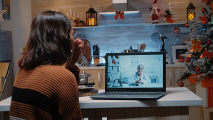 Fototapeta na wymiar Sick young woman using telemedicine on laptop for medical prescription from doctor. Patient asking about healing treatment to cure disease for christmas eve dinner celebration party