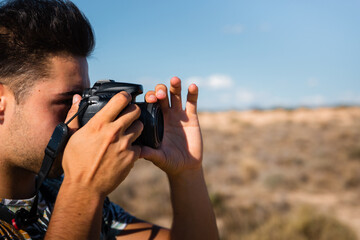 Young man with a camera in Bardenas Reales desert, Navarra, Basque Country.