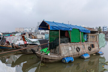 Fototapeta na wymiar Traditional Vietnamese river House boat on canal at district seven Ho Chi Minh City, Vietnam. Architecture is featured on river bank.