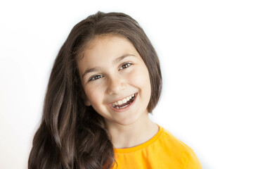 Happy positive smiling child girl with a long hair in yellow T-shirt isolated on white background