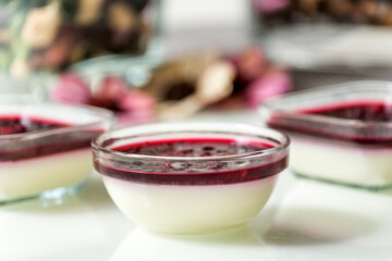 Delicious panna cotta with with raspberry sauce on white table
