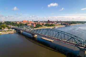 Torun, a Polish city during the day. A sunny and slightly cloudy day in Toruń on the Vistula River. - obrazy, fototapety, plakaty
