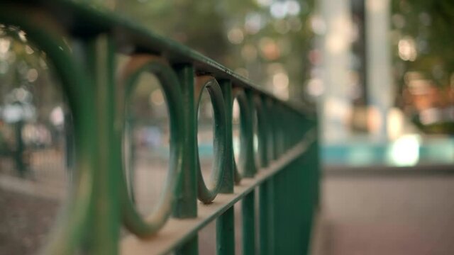 Close-up of green metal fence with blurry background
