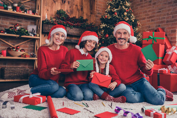 Portrait of beautiful handsome cheerful family making craft wiriting wish list dream at decorated loft home indoors