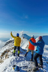 friends stands on mountain top and looks at mountains