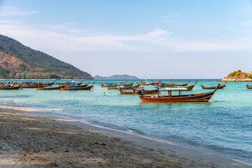Fototapeta na wymiar Wooden long-tail boat anchored on the beach in tropical sea at Koh Lipe