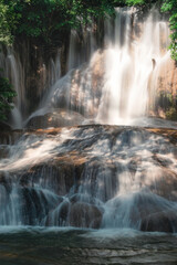 Sai Yok Noi waterfall flowing on limestone in tropical rainforest at national park