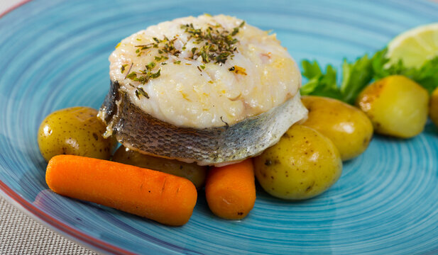 Steak of cod by rustically frying and served with boiled potatoes, carrots and greens