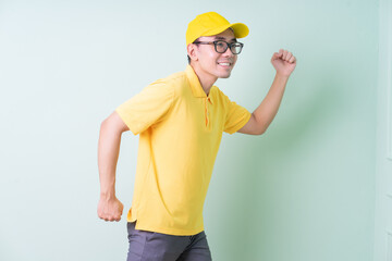 Young Asian delivery man posing on green background