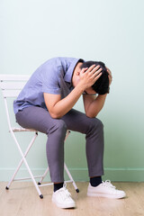 Young Asian buisnessman sitting on chair in green background