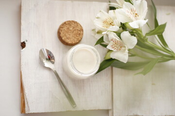 Fototapeta na wymiar White creme yoghurt on white background on white wooden table 