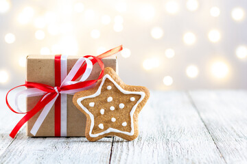 Gingerbread star and box of gift on bokeh lights background