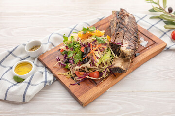 ruby on a bone with arugula and vegetable side dish 