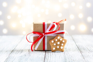 Gingerbread star and box of gift on bokeh lights background