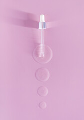pipette drops of serum on pink background