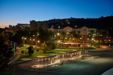 Fountain and the street bar in the campa de los Ingleses at night, Bilbao