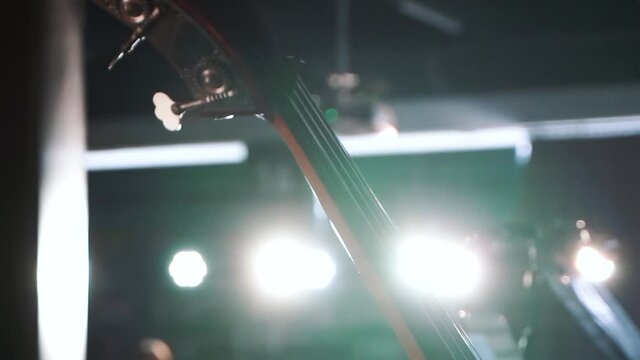 the viola stands on the piano and sparkles in the shadows and light being in the theater before the performance