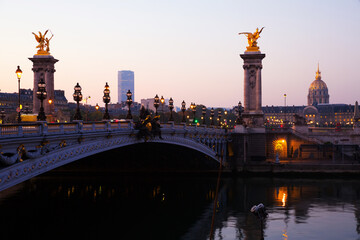 Fototapeta na wymiar Early morning view of famous Alexandre III bridge across Seine river in Paris and golden dome of Hotel of Invalides ..