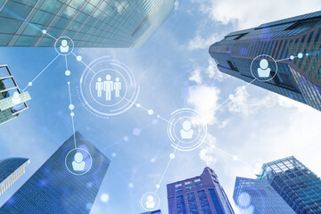 Social media icons hologram over low angle shot of Singapore skyscrapers, Southeast Asia. The...