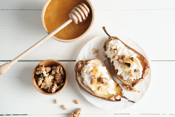 autumn menu dessert, baked pears with cream cheese and honey topping with nuts. fall season comforting food, home made sweet treats for kids. top view