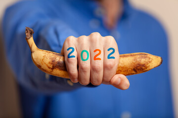 Man hand in shirt holds banana, numbers on fingers