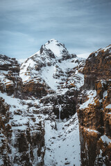 Secret canyon named Mulagljufur canyon in South Iceland. Waterfall below mountain top in winter and snow landscape. Top tourism destination. South East of Iceland, Europe