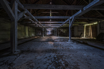 inside dark abandoned ruined wooden decaying hangar with rotting columns - obrazy, fototapety, plakaty