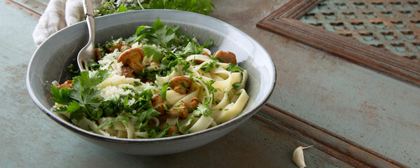 plate with tagliatelle with chanterelles on a wooden table