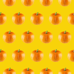 Seamless pattern from orange pumpkins on a yellow background.