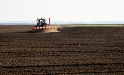 Fototapeta premium Farmer with tractor seeding