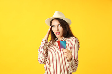 Attractive girl holds credit cards on yellow background