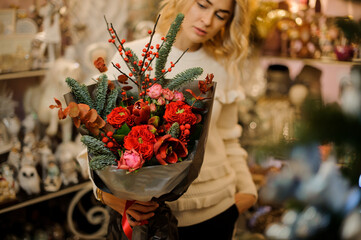 selective focus of bouquet decorated with spruce and eucalyptus branches in the hand of woman
