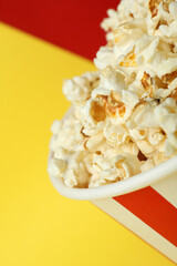 Striped paper cup with popcorn on two tone background