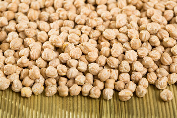 Closeup of background with raw garbanzo grains on wooden surface, healthy and nutritious food
