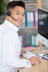 an asian businessman sitting at desk in office