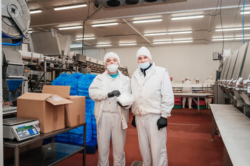 Meat processing plant.People working at a chicken factory - stock photo.Automated production line...