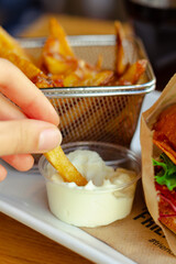 dipping potato fries in mayonnaise 