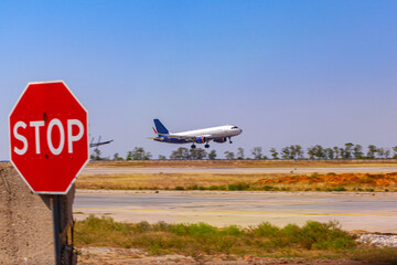 Passenger plane taking off from runway at airport on sunny day.