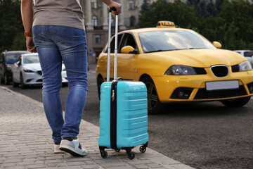 Man with suitcase near taxi car outdoors, closeup