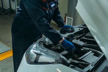 Fototapeta na wymiar car service, an employee replaces and tests the car battery