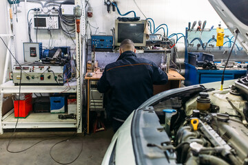 car service, an employee repairs and tests car parts