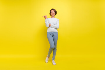 Fototapeta na wymiar Photo of promoter pretty lady direct thumb empty space wear blue sweater isolated yellow color background