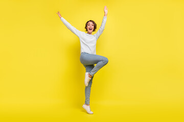 Fototapeta na wymiar Photo of carefree crazy lady raise hands dance have fun wear blue sweater isolated yellow color background